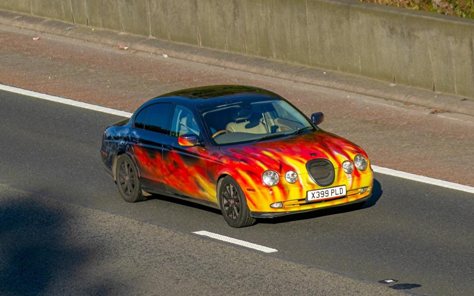 Jaguar S-Type V8 Auto 3996cc petrol saloon; UK Vehicular traffic, transport, modern, custom, Jaguar saloon cars, self adhesive sign vinyl flames, vehicle livery, wall art, vehicle wrap, fleet, commercial, vehicle wrapping on motors south-bound on the 3 lane M6 motorway highway. UK - Alamy