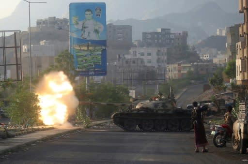 Yemeni fighters loyal to exiled President Abedrabbo Mansour Hadi fire from a tank during clashes with Shiite Huthi rebels in the country's third-city of Taez