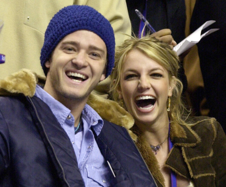 ARCHIVO - Justin Timberlake y Britney Spears en el partido de estrellas de la NBA 2002 en Filadelfia el 10 de febrero de 2002. El libro de memorias de Spears "The Woman in Me" será publicado el 24 de octubre. (Foto AP/Chris Gardner, archivo)