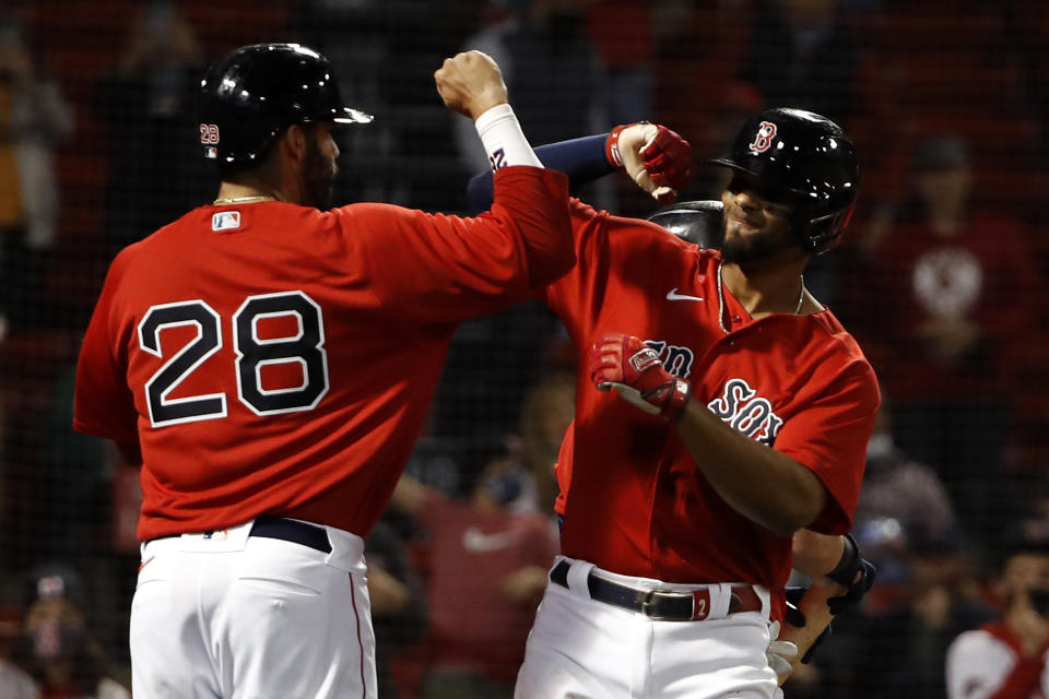 Boston Red Sox's Xander Bogaerts is congratulated by teammate J.D. Martinez after his three-run home run against the Toronto Blue Jays during the fourth inning of a baseball game Tuesday, April 20, 2021, at Fenway Park in Boston. (AP Photo/Winslow Townson)