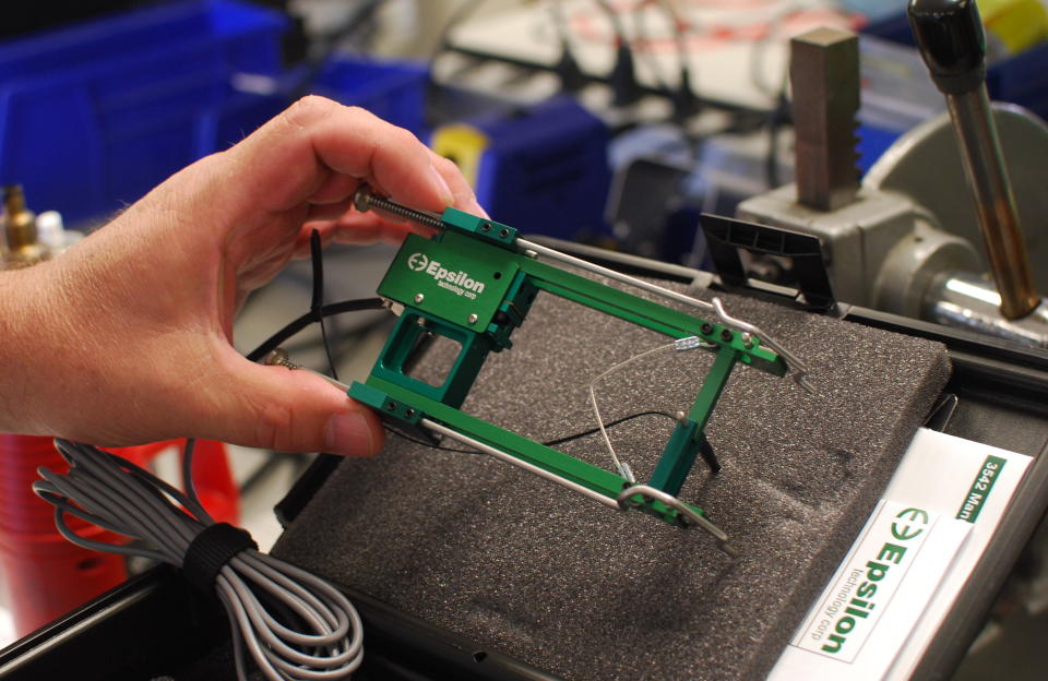 An employee at Epsilon Technology shows an extensometer used to test engineering materials like metals, composites, and plastics. Credit: Brian Cheung / Yahoo Finance