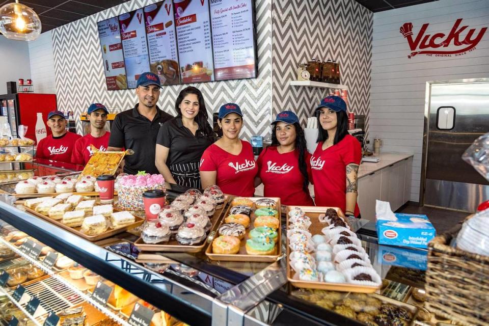 Lisy Zambrana y Relvis Diaz, (vestidos de negro) con los empleados de la nueva franquicia de Vicky Bakery, frente al Tropical Park, en el suroeste de Miami.