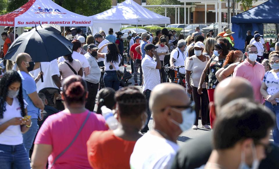 People wait in line for hours at a pop-up COVID-19 vaccination site in the parking lot of Bravo Supermarket in Orlando, Fl., on April 9, 2021. The one-day mobile site offered 400 doses of the one-shot Johnson and Johnson vaccine. (Paul Hennessy / SOPA Images/Sipa USA via AP)