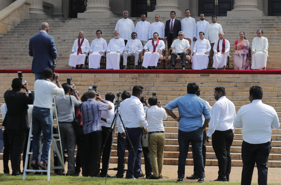Sri Lankan president Gotabaya Rajapaksa, seated fifth from right, sits for photographs with his new cabinet members in Colombo, Sri Lanka, Friday, Nov. 22, 2019. Rajapaksa, who was elected last week, said he would call a parliamentary election as early as allowed. The parliamentary term ends next August, and the constitution allows the president to dissolve Parliament in March and go for an election. (AP Photo/Eranga Jayawardena)
