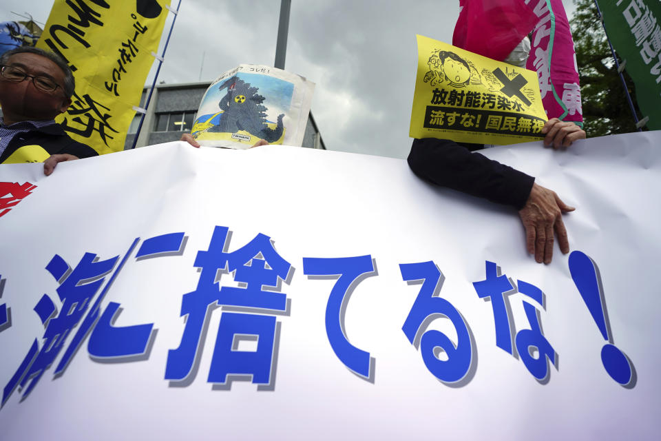 People hold a banner that partially reads "Don't dump into the sea" during a rally outside the prime minister's office in Tokyo Tuesday, April 13, 2021. Japan's government decided Tuesday to start releasing massive amounts of treated radioactive water from the wrecked Fukushima nuclear plant into the Pacific Ocean in two years, an option fiercely opposed by local fishermen and residents. (AP Photo/Eugene Hoshiko)