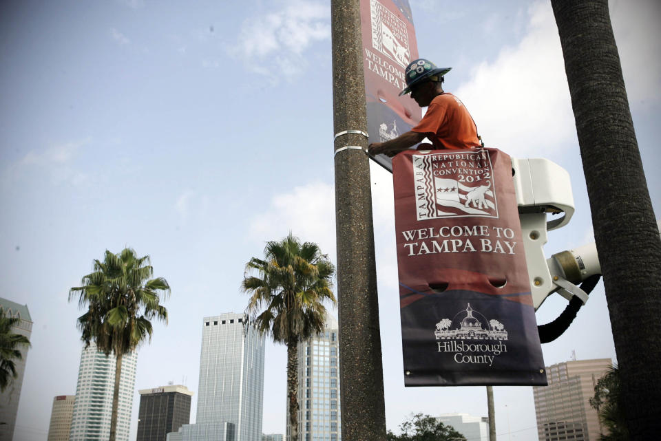 FILE In this Wednesday, August 8, 2012 file photo, a worker begins installing banners for the Republican National Convention in front of the Tampa Bay Times Forum, in Tampa, Fla. It's no coincidence, then, that the Republicans have placed their convention here; Mitt Romney desperately needs to win Florida if he is going to defeat President Barack Obama. (AP Photo/The Tampa Bay Times, Edmund D. Fountain)