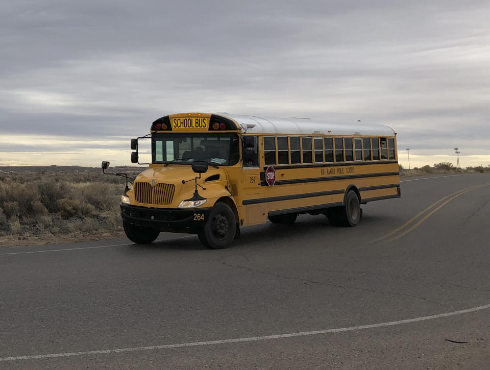 A school bus evacuates students from Sue V. Cleveland High School in Rio Rancho, New Mexico, on Thursday, Feb. 14, 2019, after a shot was fired on the campus. Police and school officials said no one was injured and a suspect was taken into custody. (AP/Russell Contreras)