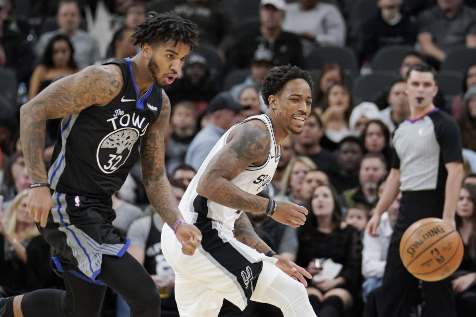 San Antonio Spurs' DeMar DeRozan, right, and Golden State Warriors' Marquese Chriss chase the ball during the first half of an NBA basketball game, Tuesday, Dec. 31, 2019, in San Antonio. (AP Photo/Darren Abate)