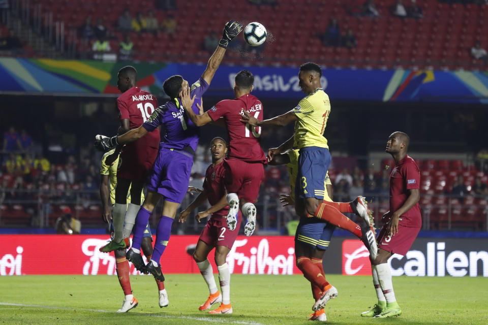 Qatar's goalkeeper Saad Al Sheeb, second from left, pushes out the ball during a Copa America Group B soccer match against Colombia at the Morumbi stadium in Sao Paulo, Brazil, Wednesday, June 19, 2019. (AP Photo/Victor R. Caivano)
