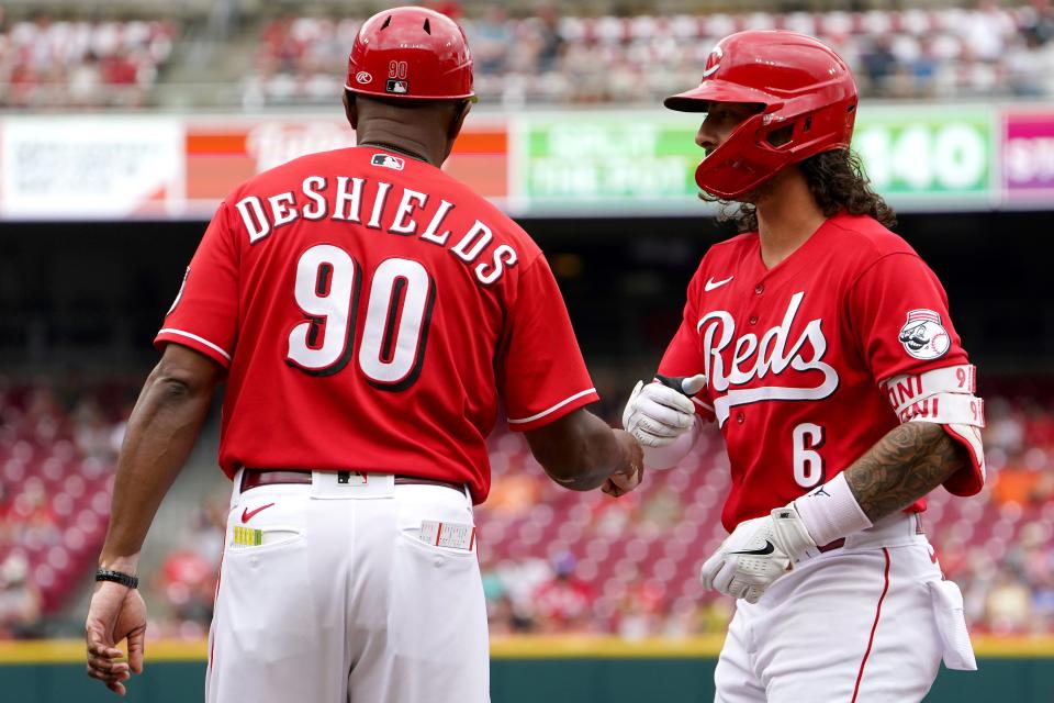 Jonathan India fist bumps Reds first-base coach Delino DeShields after hitting a single on July 31.