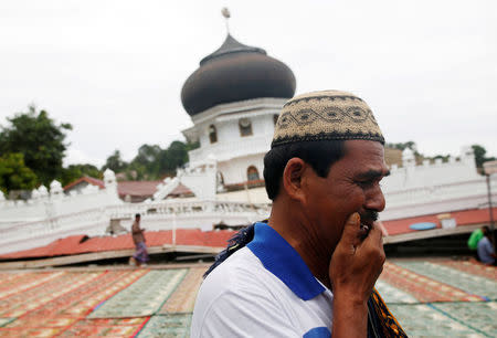 A Muslim man weeps as he arrives for Friday prayers at Jami Quba mosque which collapsed during this week's earthquake in Pidie Jaya, Aceh province, Indonesia December 9, 2016. REUTERS/Darren Whiteside