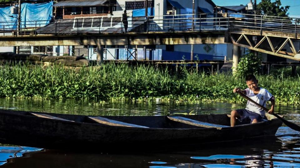 Niño navegando en bote en la Amazonía colombiana.