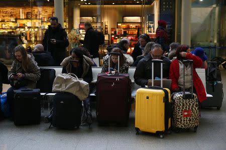 Passengers use their mobile phones at St Pancras International Station in London, January 17, 2015. REUTERS/Stefan Wermuth