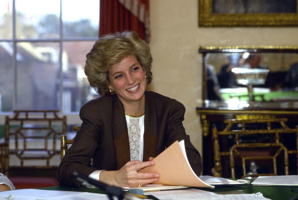 <p>Princess Diana holds papers at her dining room table at home in <a href="https://www.elledecor.com/celebrity-style/celebrity-homes/a9585893/buckingham-palace-secrets/" rel="nofollow noopener" target="_blank" data-ylk="slk:Kensington Palace;elm:context_link;itc:0;sec:content-canvas" class="link ">Kensington Palace</a> during a meeting in 1986. </p>