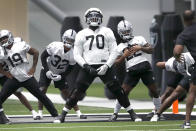 Las Vegas Raiders offensive tackle Alex Leatherwood (70) warms up with teammates during NFL football training camp Saturday, July 30, 2022, in Henderson, Nev. (AP Photo/Steve Marcus)