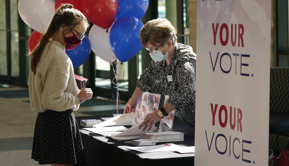 During a break between morning church services, Beverly Sides, right, with the Prestonwood Cultural Impact Team shows Suzie Brewer election voter guides for various north Texas counties at Prestonwood Baptist Church Sunday, Oct. 11, 2020, in Plano, Texas. Evangelical churches and their suburban members are a key to President Trump's voter support in Texas. (AP Photo/LM Otero)