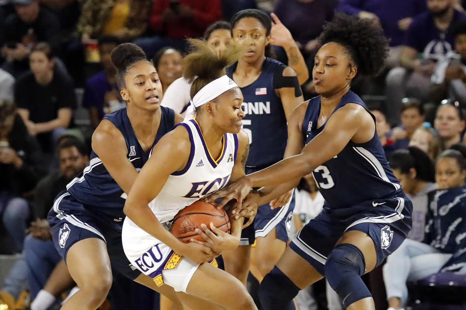 East Carolina's Necole Hope, center, gets tied up by Connecticut's Christyn Williams, right, and Aubrey Griffin, left, during the first half of an NCAA college basketball game, Saturday, Jan. 25, 2020 in Greenville, N.C. (AP Photo/Karl B DeBlaker)