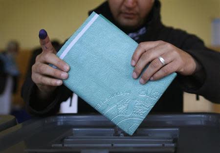 A man places his ballot paper in a ballot box after voting at a polling station in Kabul April 5, 2014. REUTERS/Tim Wimborne