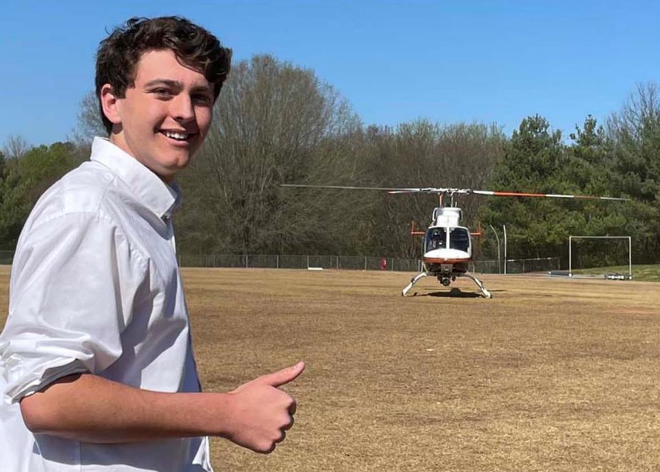 Knoxville Catholic High School junior Andrew Dreiser gives the thumbs-up to UT LIFESTAR helicopter as it lands at the school March 31.