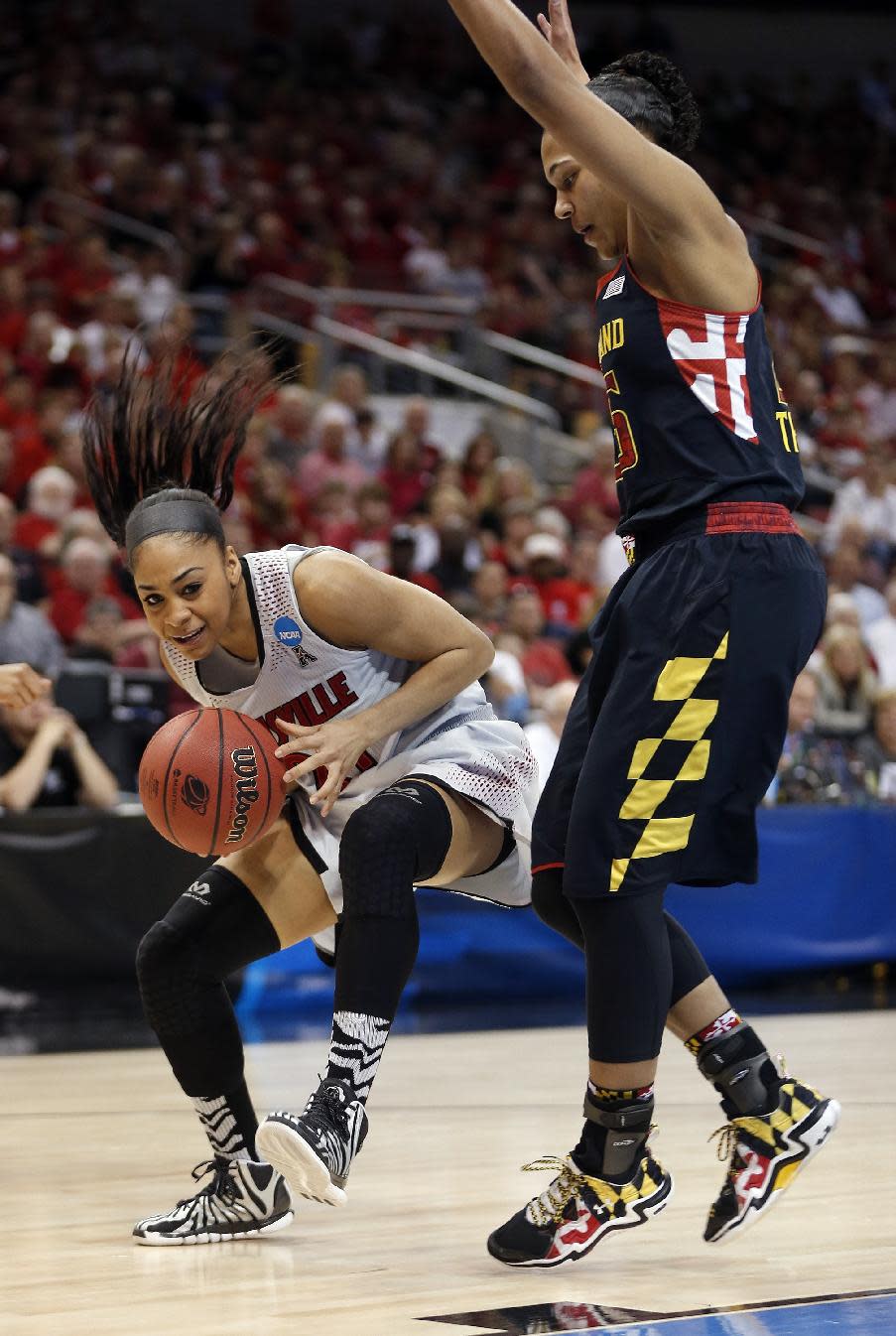 Louisville guard Bria Smith (21) drives against Maryland forward Alyssa Thomas (25) during the first half of a regional final in the NCAA women's college basketball tournament, Tuesday, April 1, 2014, in Louisville, Ky. (AP Photo/John Bazemore)