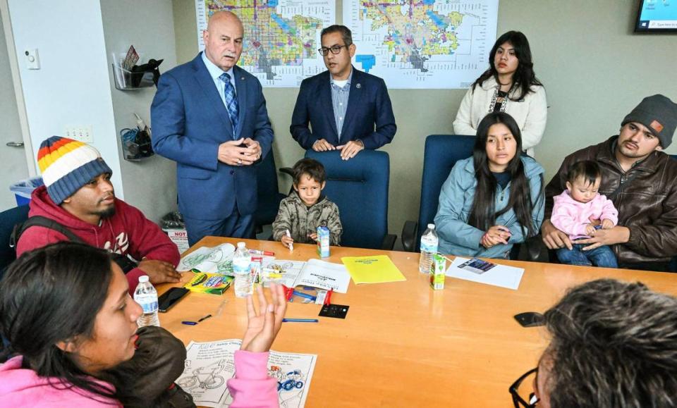 Fresno Mayor Jerry Dyer, top left, is briefed on the arrival of migrant families and individuals seeking asylum from Fresno Councilmember Miguel Arias, center, at Fresno City Hall on Friday, Feb. 2, 2024.