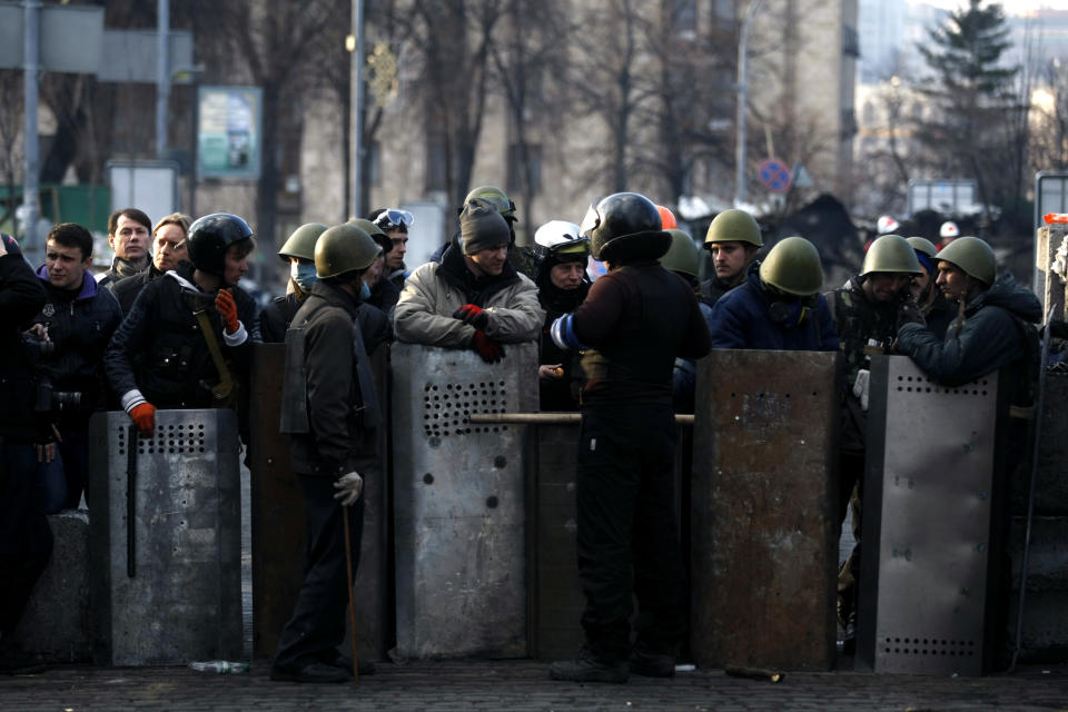 Anti-government protesters man a barricade on the outskirts of Independence Square in Kiev, Ukraine, Friday, Feb. 21, 2014. In a day that could significantly shift Ukraine’s political destiny, opposition leaders signed a deal Friday with the country’s beleaguered president that calls for early elections, a new constitution and a new unity government. (AP Photo/ Marko Drobnjakovic)