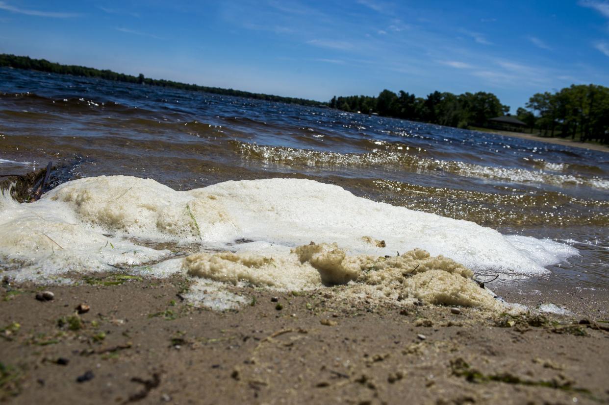 In this June 6, 2018 photo, PFAS foam washes up on the shoreline of Van Etten Lake in Oscoda Township, Mich., near Wurtsmith Air Force Base. 