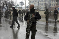 FILE- in this Feb. 11, 2020, photo, national army soldiers stand guard at the site of suicide attack near the military academy in Kabul, Afghanistan, A United Nations report says Afghanistan passed a grim milestone with more than 100,000 civilians killed or hurt in the last 10 years since the international body began documenting casualties in a war that has raged for 18 years. (AP Photo/Rahmat Gul, file)