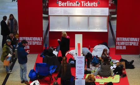 People who camped-out overnight, sit in their sleeping bags as they queue to buy tickets for the upcoming 66th Berlinale International Film Festival in Berlin February 8, 2016. REUTERS/Hannibal Hanschke