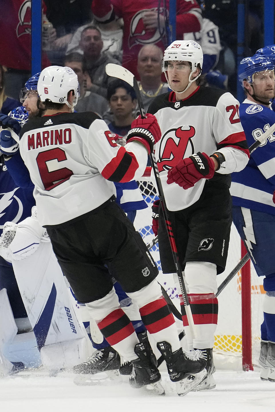 New Jersey Devils center Michael McLeod (20) celebrates his goal against the Tampa Bay Lightning with defenseman John Marino (6) during the second period of an NHL hockey game Thursday, Jan. 11, 2024, in Tampa, Fla. (AP Photo/Chris O'Meara)