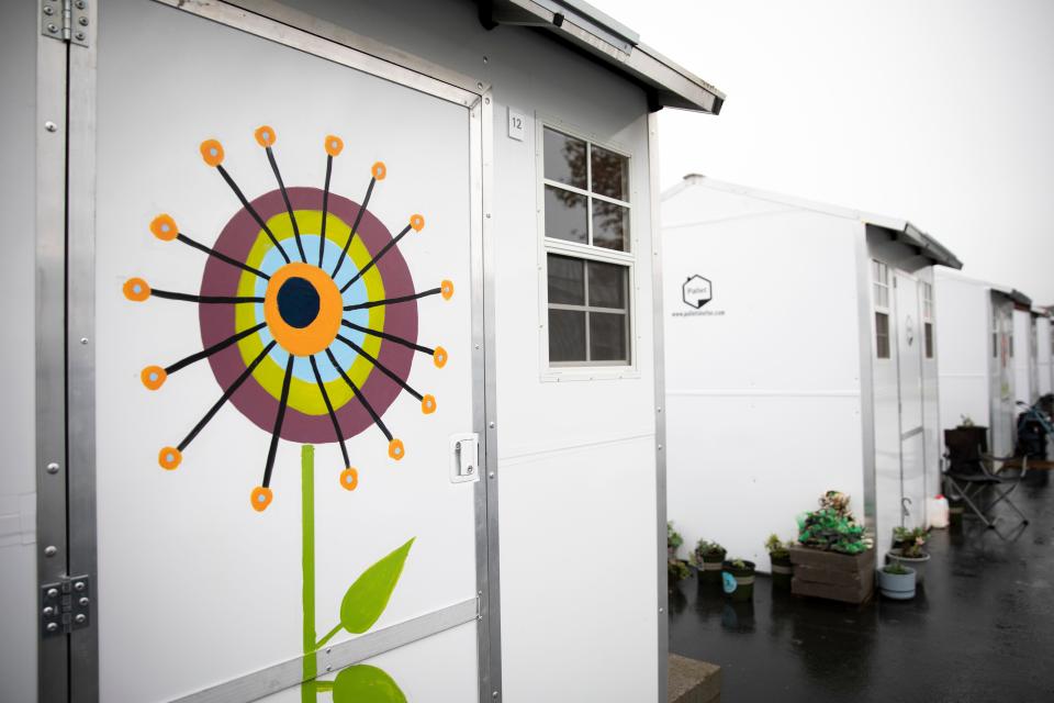 Flowers are painted on the doors of micro shelters at Church at the Park on Dec. 17, 2021, in Salem, Ore.