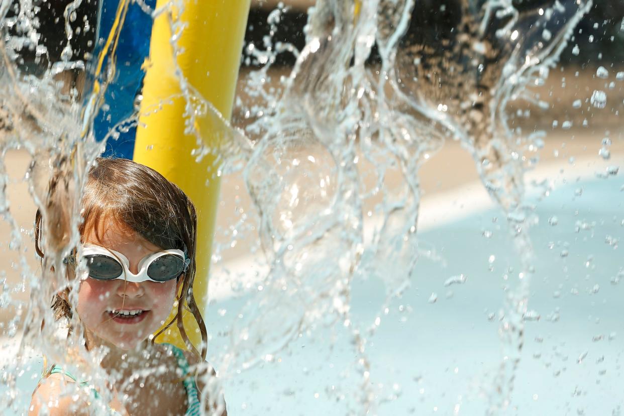 FILE - A little girl cools off at the Virginia Callaway-Cofer Walker Park Splash Pad on a hot summer day on Wednesday, June 15, 2022. Most of Georgia is under a heat advisory and it's only supposed to get hotter with temperatures predicted to be in the 90s.