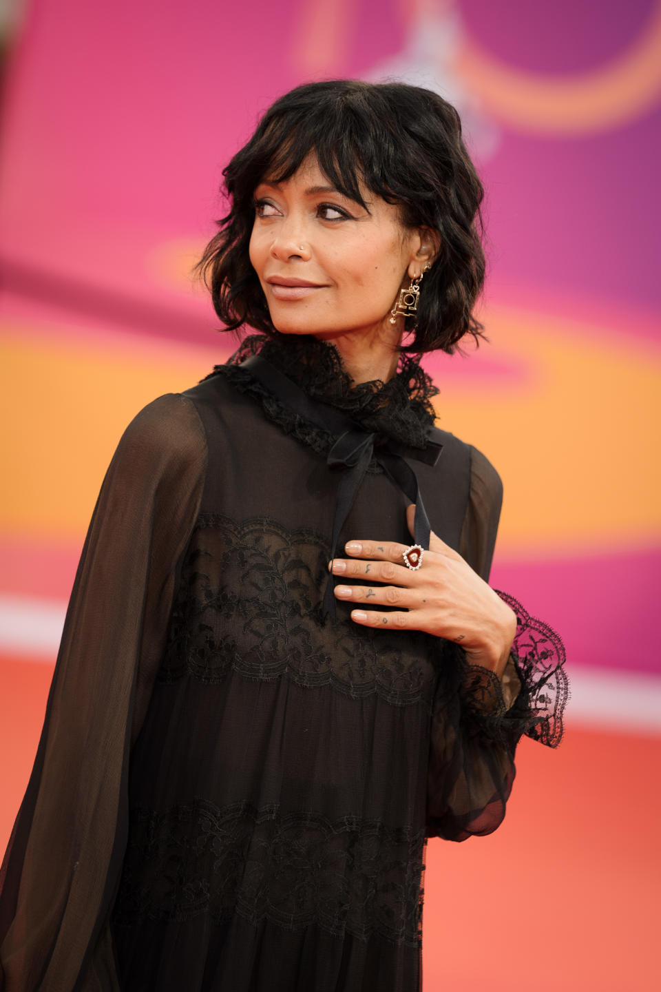 Thandiwe Newton on the red carpet wearing a long, black lace dress with sheer sleeves and an elegant high neckline