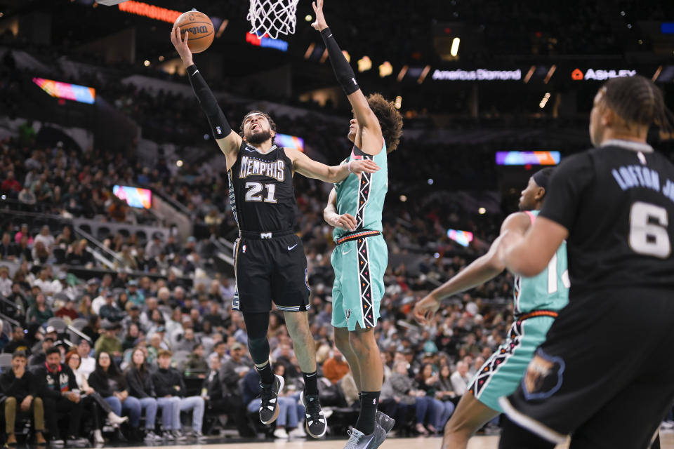 Memphis Grizzlies' Tyus Jones (21) goes to the basket against San Antonio Spurs' Dominick Barlow during the second half of an NBA basketball game, Friday, March 17, 2023, in San Antonio. (AP Photo/Darren Abate)