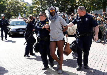 Police detain a person as they work to keep opposing protesters apart over the cancelation of conservative commentator Ann Coulter's speech at the University of California, Berkeley, in Berkeley, California, U.S., April 27, 2017. REUTERS/Stephen Lam