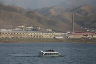 Chinese cruise boat passes buildings in North Korea's Sinuiju on the Yalu River, in Dandong