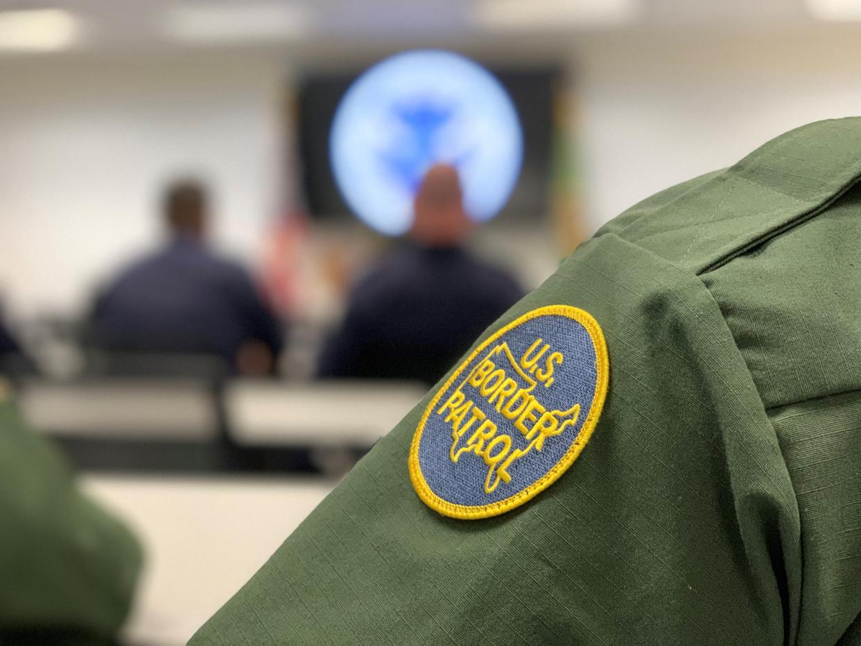 U.S. Border Patrol agents and customs officers wait for the arrival of Homeland Sec. Kirstjen Nielsen in Yuma on April 4, 2019.