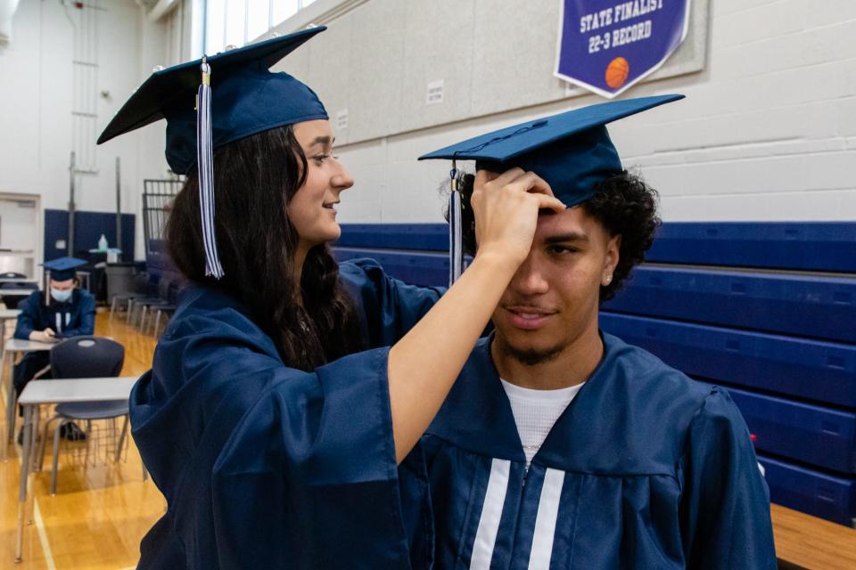 Gianna Gervasi adjusts Derek Williams’ cap inside the gymnasium before making their way to Veterans Memorial Stadium for the Rockland High School graduation ceremony on Friday, June 4, 2021. Mike Mejia/For The Patriot Ledger