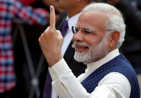 Prime Minister Narendra Modi shows his ink-marked finger after casting his vote outside a polling station during the last phase of Gujarat state assembly election in Ahmedabad, December 14, 2017. REUTERS/Amit Dave