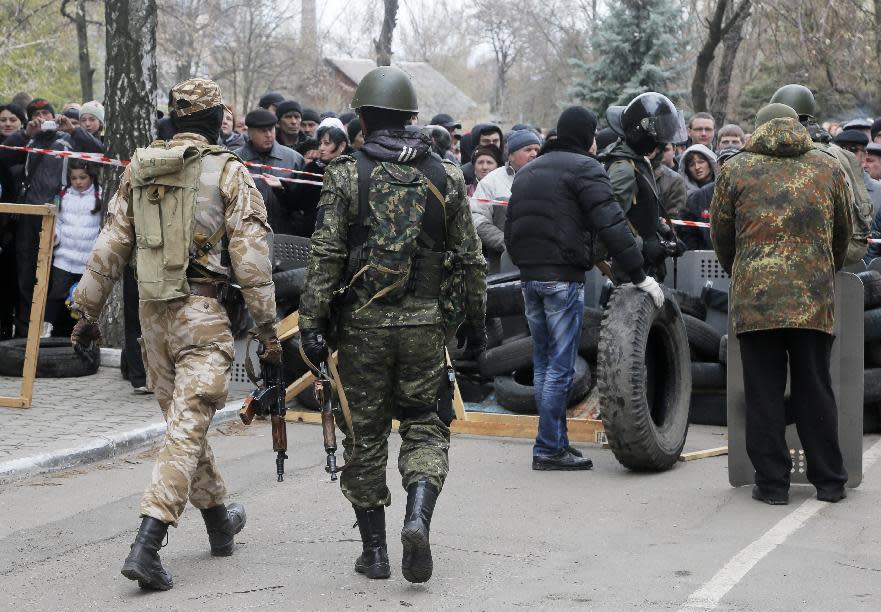 Armed pro-Russian activists occupy the police station in the eastern Ukrainian town of Slovyansk carrying riot shields on Saturday, April 12, 2014. Pro-Moscow protesters have seized a number of government buildings in the east over the past week, undermining the authority of the interim government in the capital, Kiev. (AP Photo/Efrem Lukatsky)