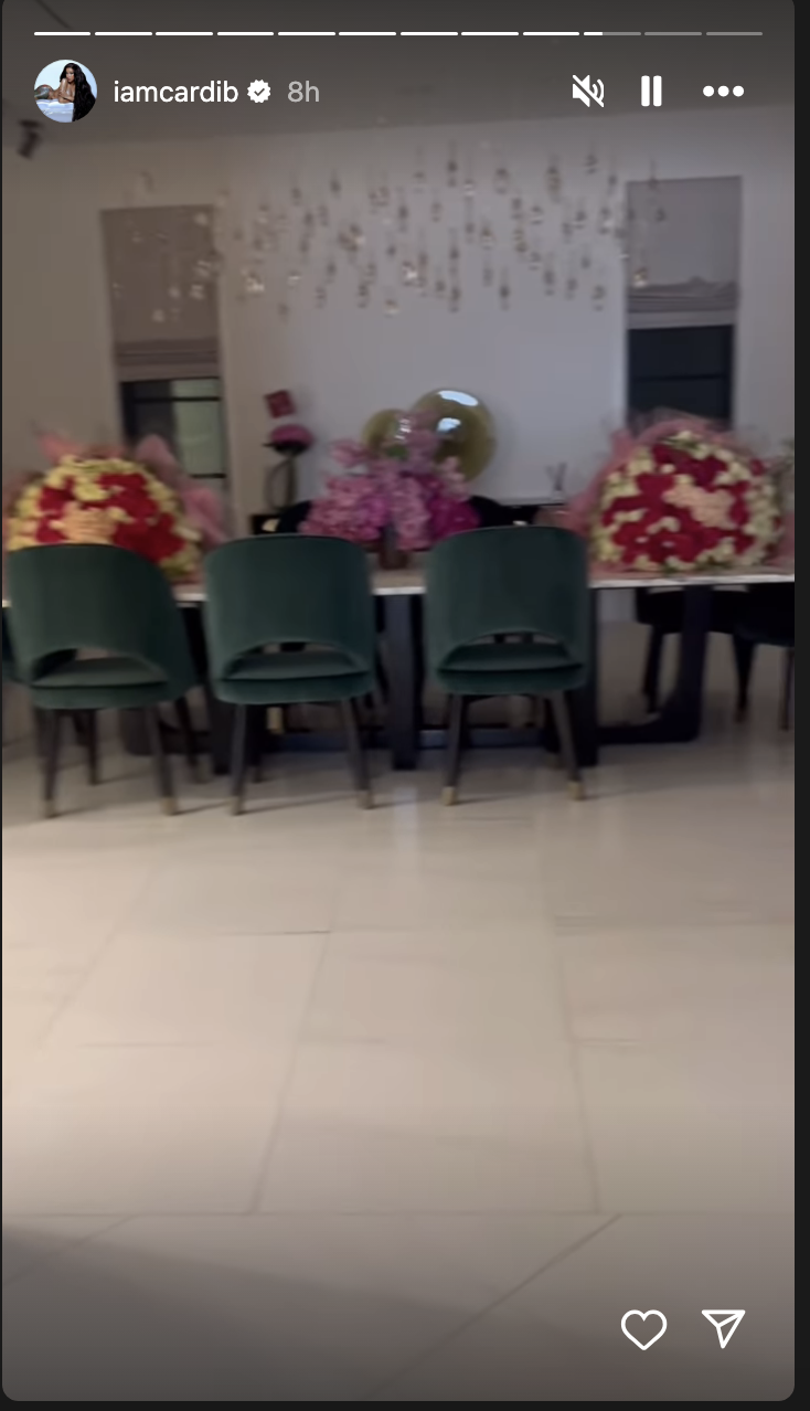 Three teal chairs in front of a table with floral arrangements in a room with balloons