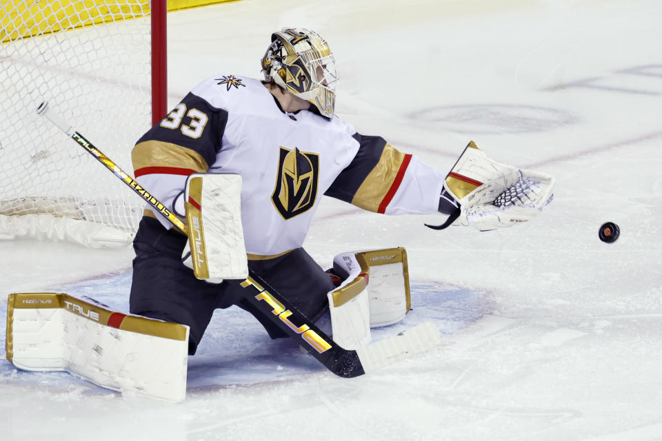Vegas Golden Knights goalie Adin Hill makes a save on a Calgary Flames shot during the first period of an NHL hockey game, Thursday, March 14, 2024 in Calgary, Alberta. (Larry MacDougal/The Canadian Press via AP)