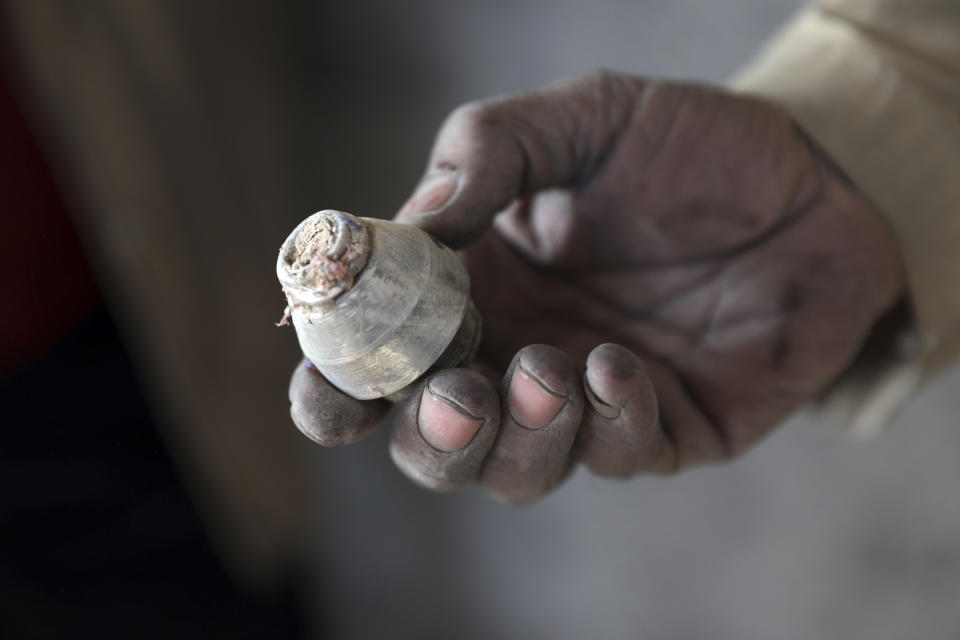 An Afghan man holds the part of a mortar shell after an attack site in Kabul, Afghanistan, Saturday, Nov. 21, 2020. Mortar shells slammed into different parts of the Afghan capital on Saturday. (AP Photo/Rahmat Gul)