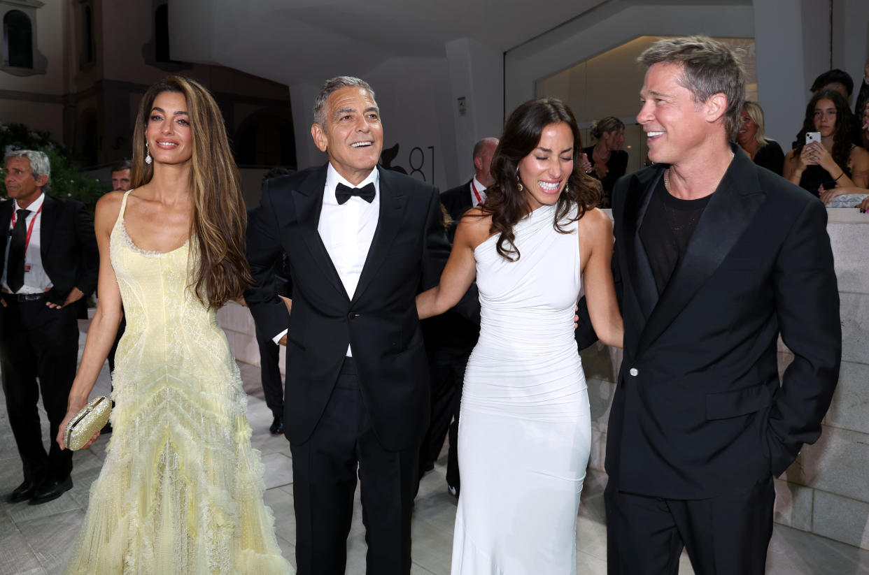 Amal Clooney, George Clooney, Ines de Ramon and Brad Pitt stand together at a movie premiere.