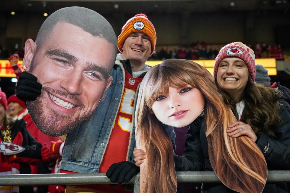 Fans wave big heads of Travis Kelce and Taylor Swift after the fourth quarter of the NFL Week 17 game between the Kansas City Chiefs and the Cincinnati Bengals at Arrowhead Stadium in Kansas City, Mo., on Sunday, Dec. 31, 2023. The Chiefs won 25-17 to clinch the AFC West Championship.