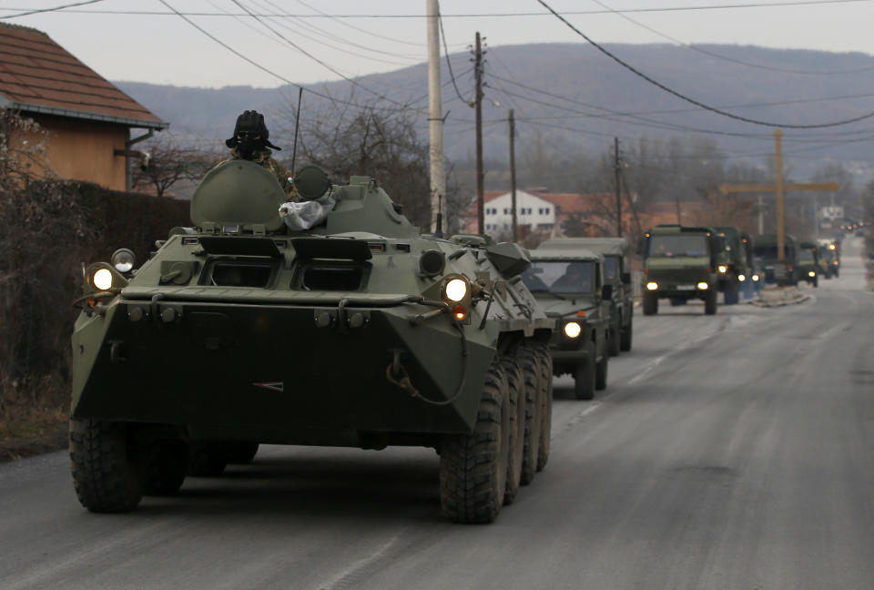 A convoy of NATO-led peacekeeping force KFOR vehicles travels on the road near the village Rudare, north of Serb-dominated part of ethnically divided town of Mitrovica, Kosovo, Thursday, Dec. 13, 2018. Kosovo's parliament on Friday is expected to approve legislation to turn existing 4,000-strong security forces into an army. (AP Photo/Darko Vojinovic)