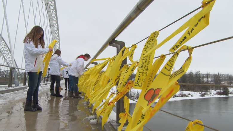 Ottawa high school students tie yellow ribbons to the Vimy Memorial Bridge