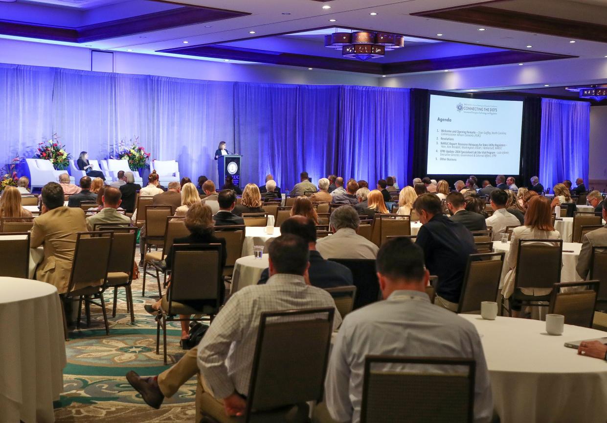 People attend a conference in a large ballroom during the National Association of Regulatory Utility Commissioners annual meeting at the La Quinta Hotel and Resort in La Quinta, Calif., Nov. 13, 2023.