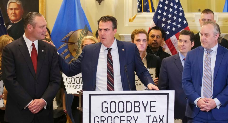 Gov. Kevin Stitt, middle, is flanked Tuesday by House Speaker Charles McCall, left, and Senate Pro Tem Greg Treat at a signing ceremony for the grocery tax cut bill in the Blue Room at the Oklahoma Capitol.