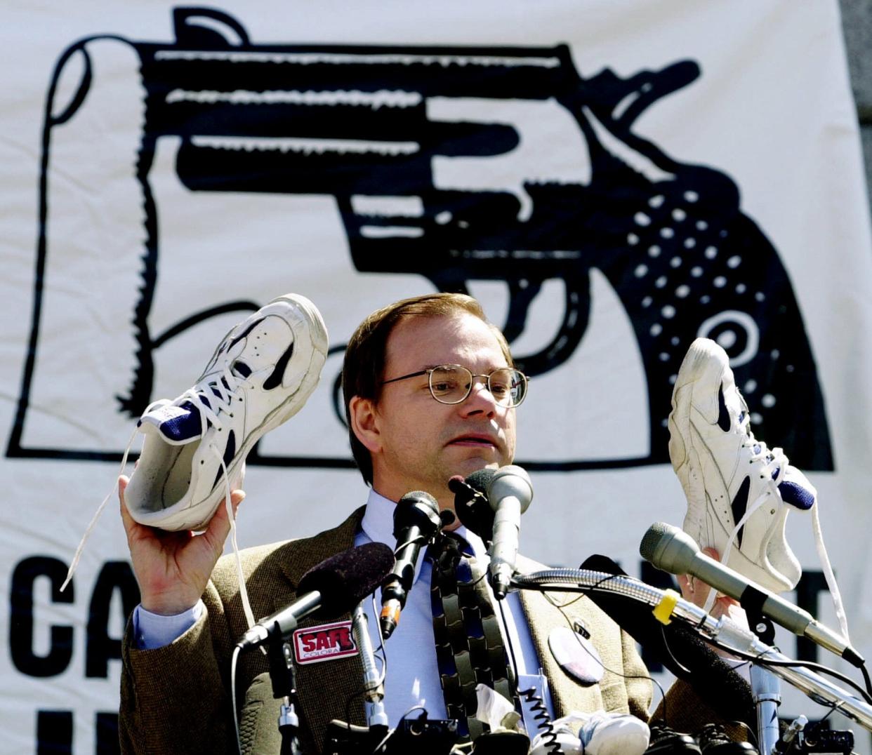 Tom Mauser holds up a pair of shoes belonging to his late son, Daniel, who was killed in the Columbine shooting, during a rally at the capitol in Denver, April 11, 2000. Mauser placed the shoes with over 4,000 other pairs, representing children killed by handguns in one year. (Photo: Ed Andrieski/AP)